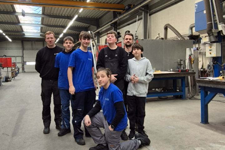 Schüler mit Ausbildern vor dem verdeckten Grill