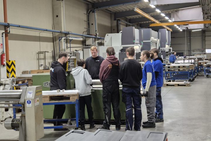 Schülergruppe vor Maschine