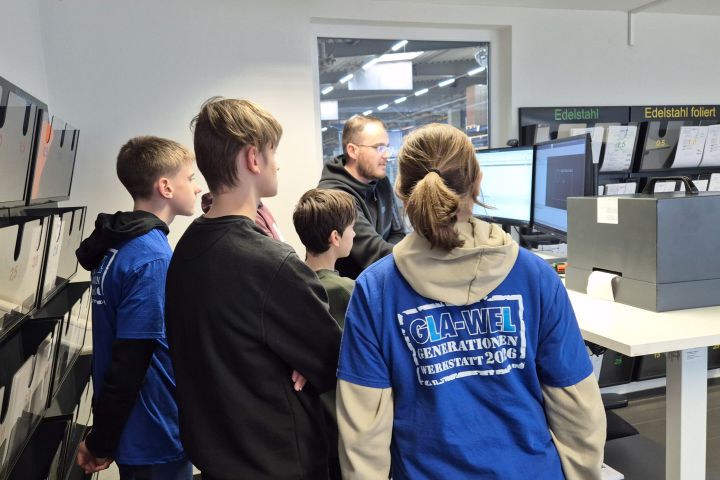 Schülergruppe und Mitarbeiter Laserprogrammierung