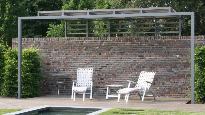 Pergola vor roter Ziegelmauer