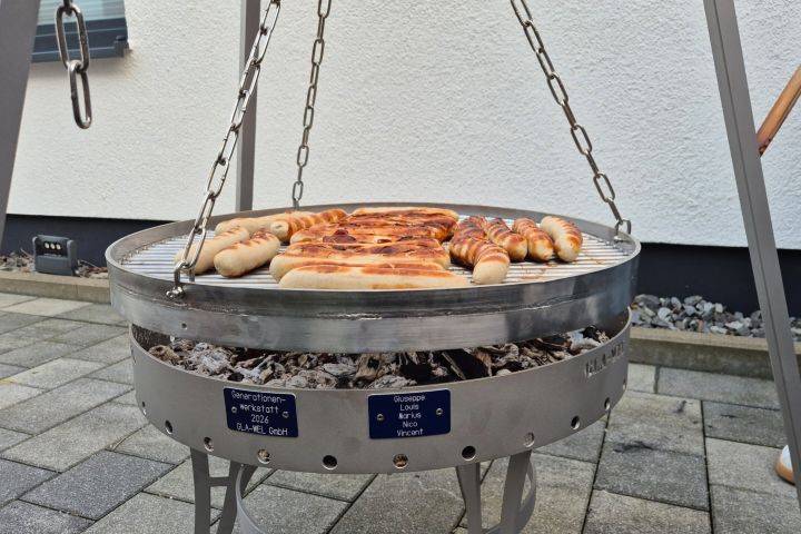 Schüler mit Ausbildern vor dem verdeckten Grill